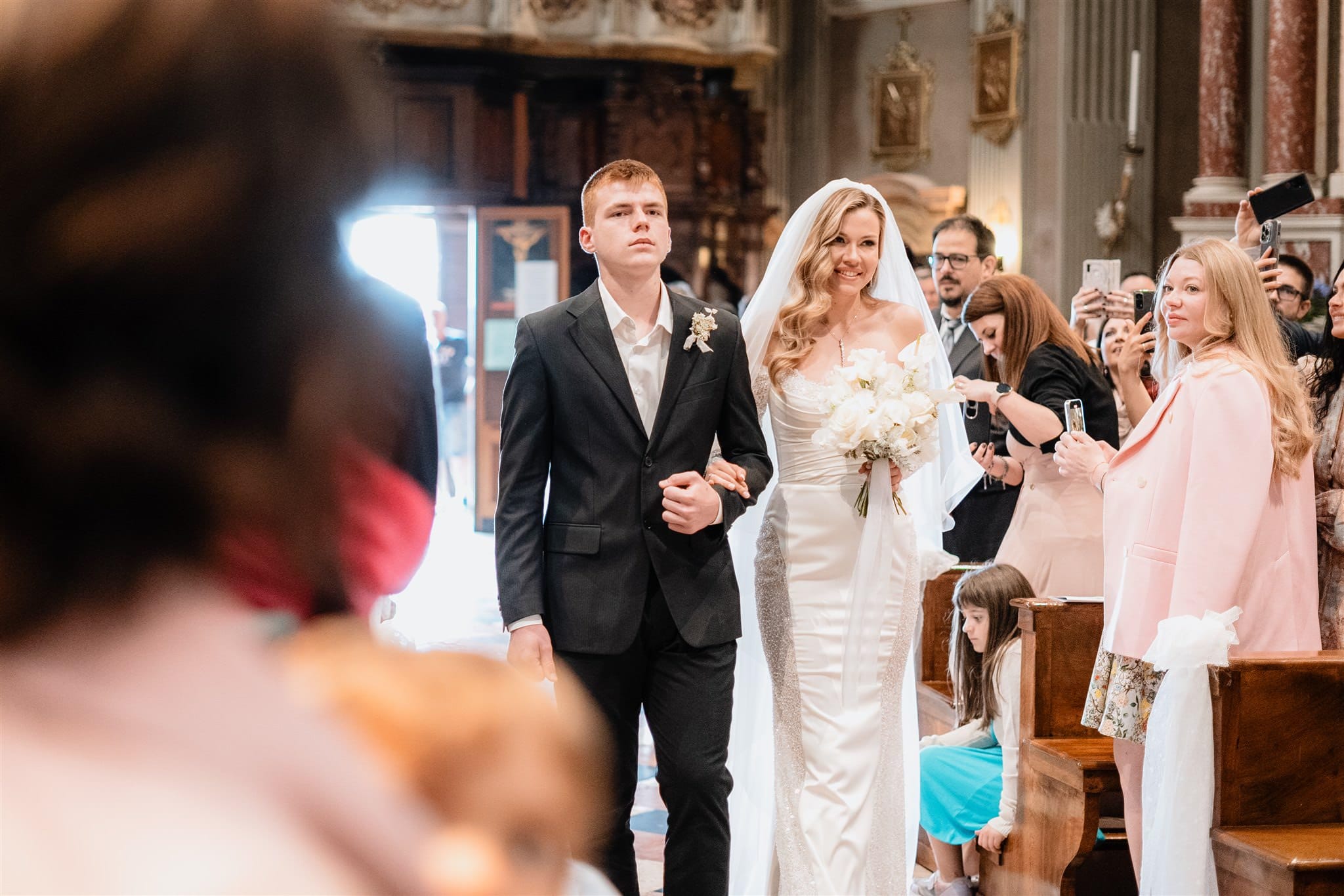 La sposa entra in chiesa a Verona: il momento che segna l’inizio del matrimonio Descrizione: Il cuore di Verona accoglie la sposa che entra in chiesa. Un momento di pura emozione, dove l’attesa lascia spazio alla magia del matrimonio. Il fotografo cattura ogni istante di questo rito sacro.