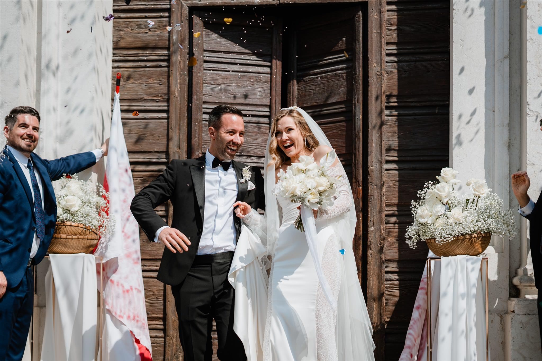 Gli sposi escono dalla chiesa a Verona, accolti dal lancio del riso da amici e familiari. Un momento carico di gioia e tradizione, che segna l'inizio della loro vita insieme. Il fotografo cattura ogni sorriso e ogni gesto in questo momento di felicità pura.