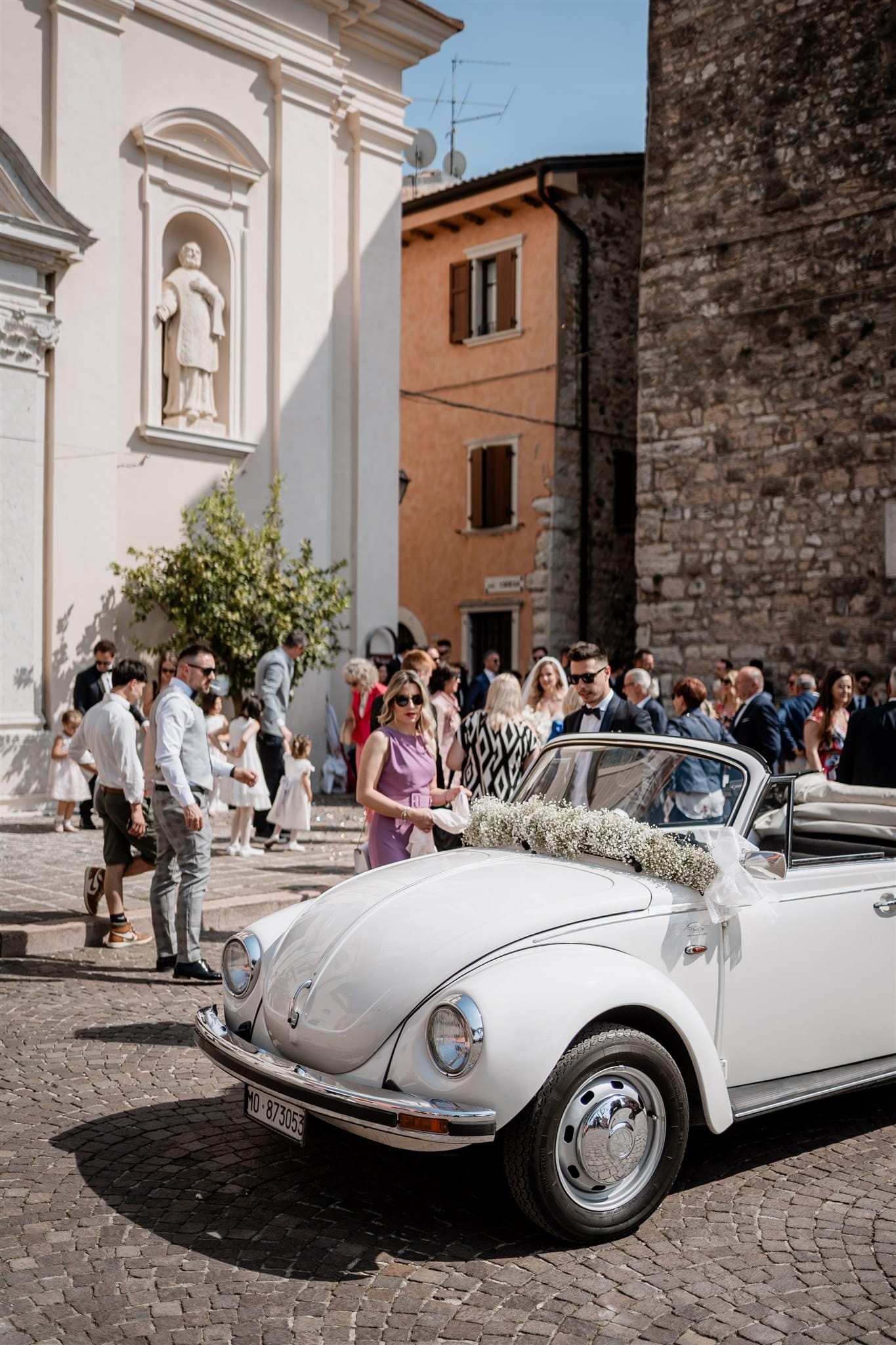Un’immagine di pura felicità mentre gli sposi escono dalla chiesa a Verona, sotto una pioggia di riso lanciato dagli invitati. Ogni sorriso e ogni gesto di festa sono immortalati dal fotografo di matrimoni per raccontare la gioia di un matrimonio appena celebrato.