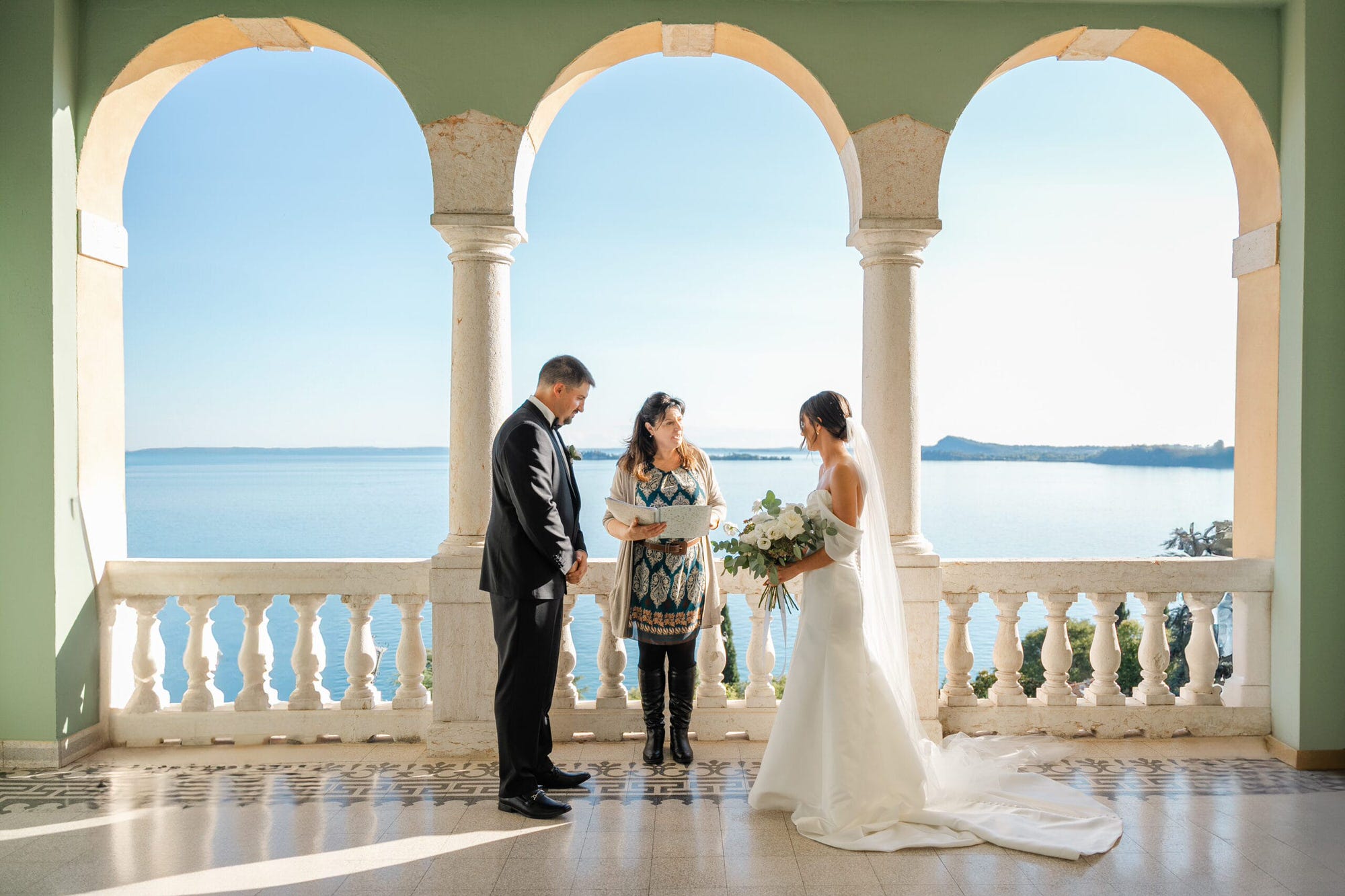 Sotto il cielo azzurro e la luce calda del sole, gli sposi si scambiano il loro primo bacio da marito e moglie. Il panorama mozzafiato sul Lago di Garda e la serenità dell’ambiente rendono questo momento unico e perfetto per un ricordo indelebile.