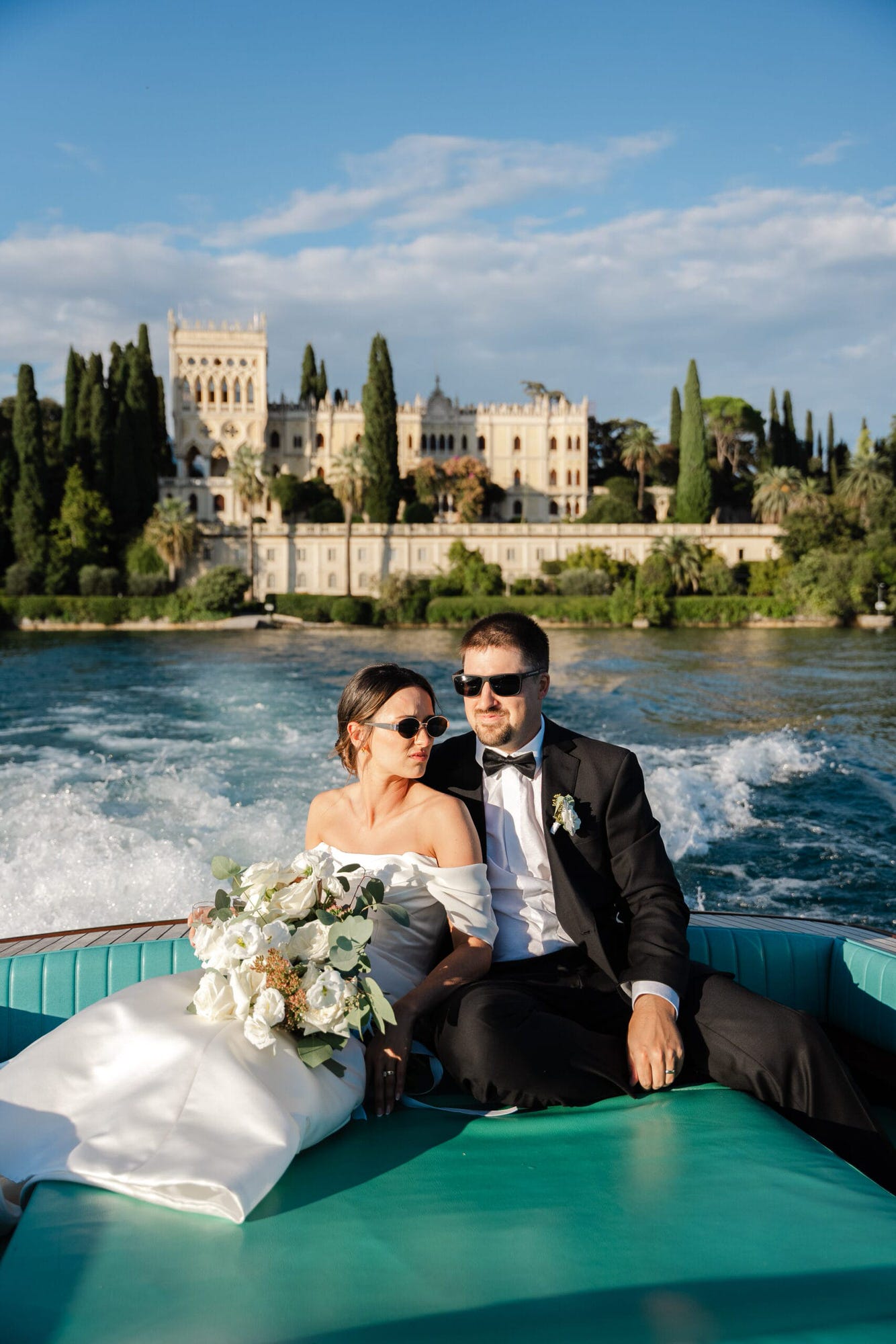 Paige e Ryan a bordo, con la villa dell'Isola del Garda che si staglia alle loro spalle