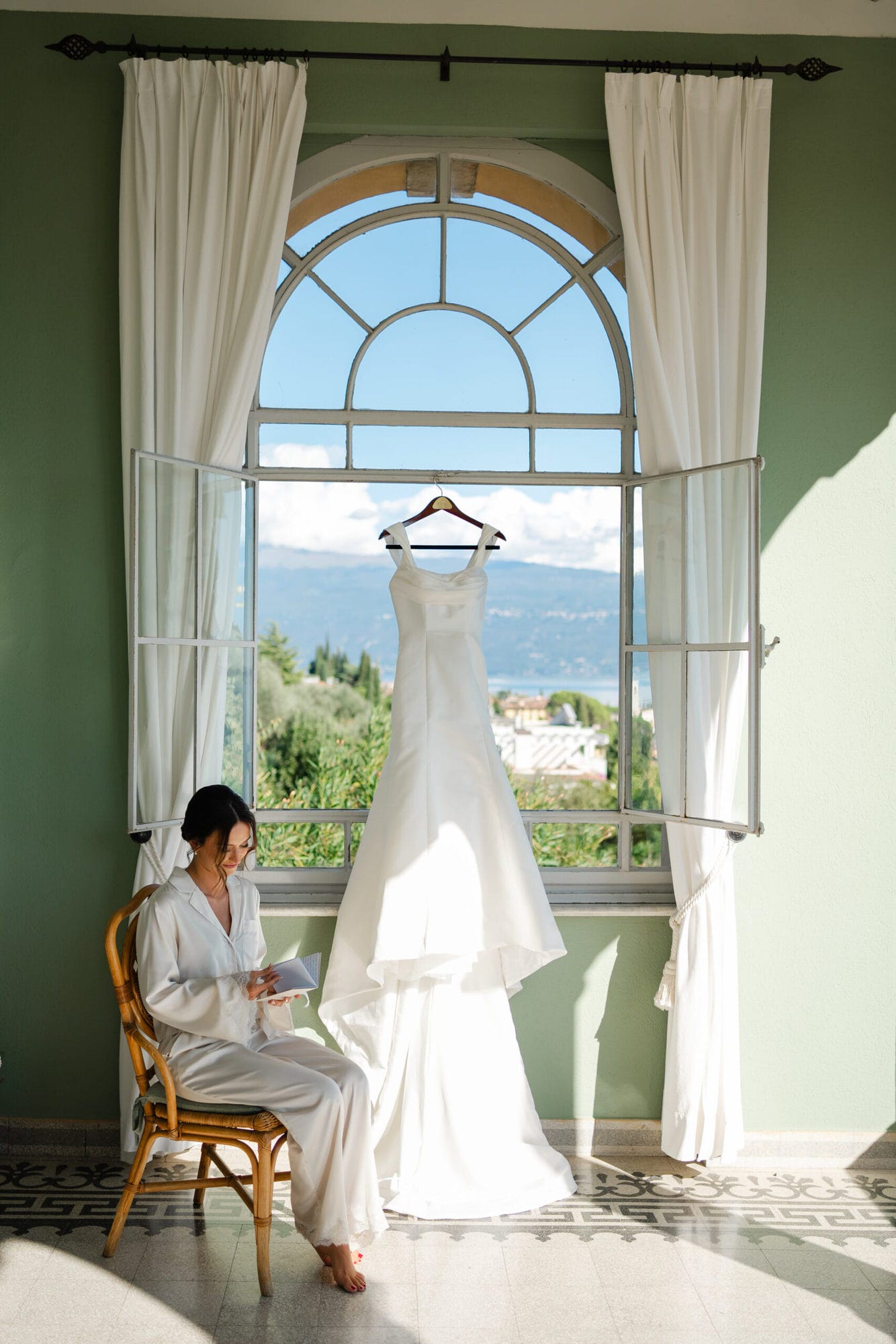 Con il Lago di Garda che si riflette nelle finestre, la sposa si prepara, immergendosi nell'emozione del giorno più importante della sua vita. La bellezza dell'ambiente rende ogni momento ancora più indimenticabile.