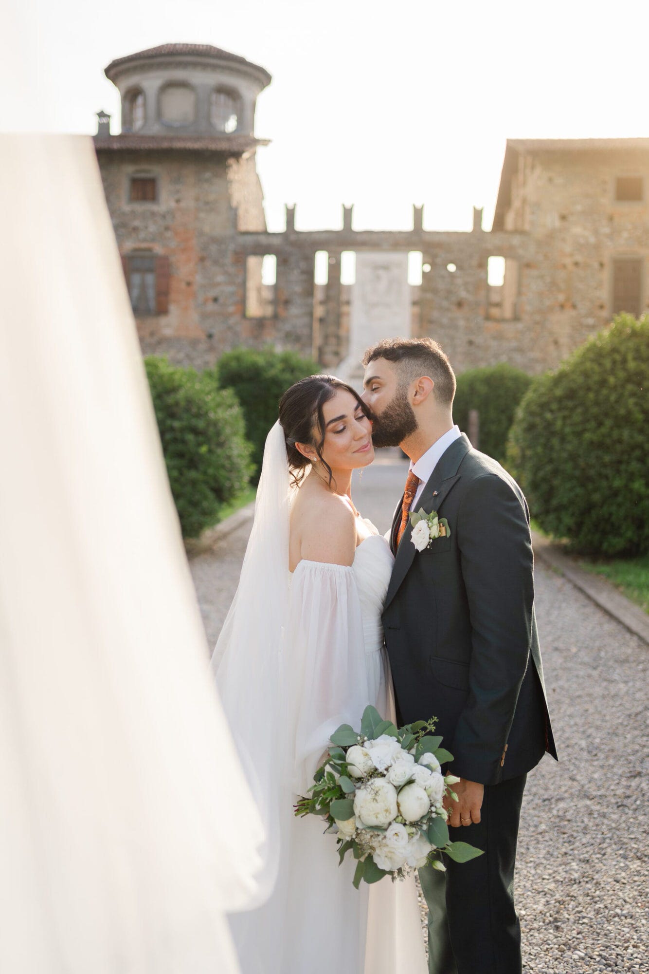 Un dolce abbraccio degli sposi in un angolo suggestivo del Castello di Cavernago, durante il loro matrimonio testimoni di Geova a Bergamo