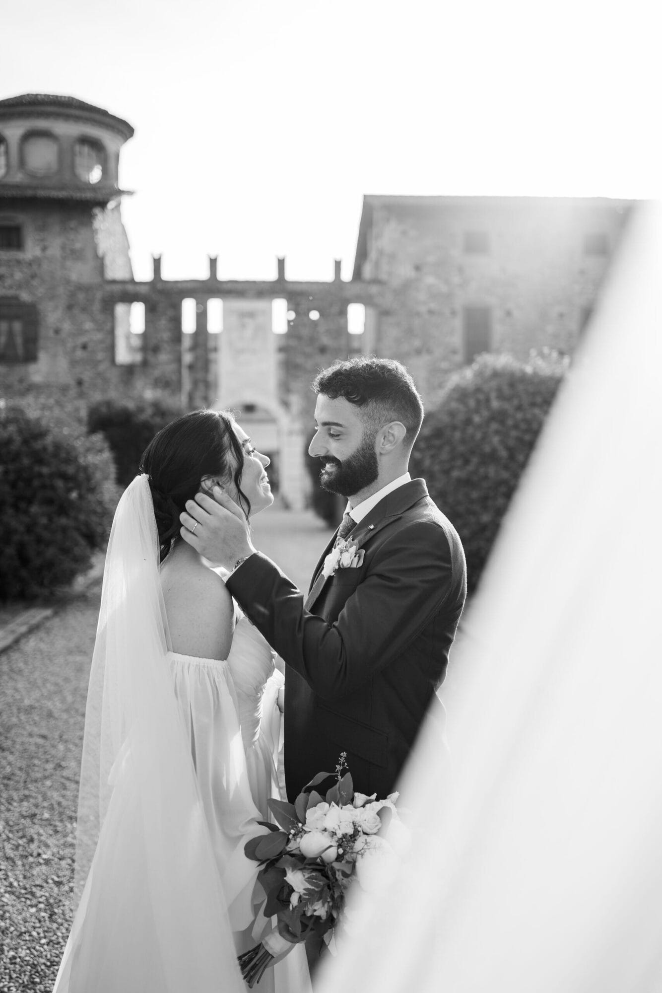 Un dolce abbraccio degli sposi in un angolo suggestivo del Castello di Cavernago, durante il loro matrimonio testimoni di Geova a Bergamo