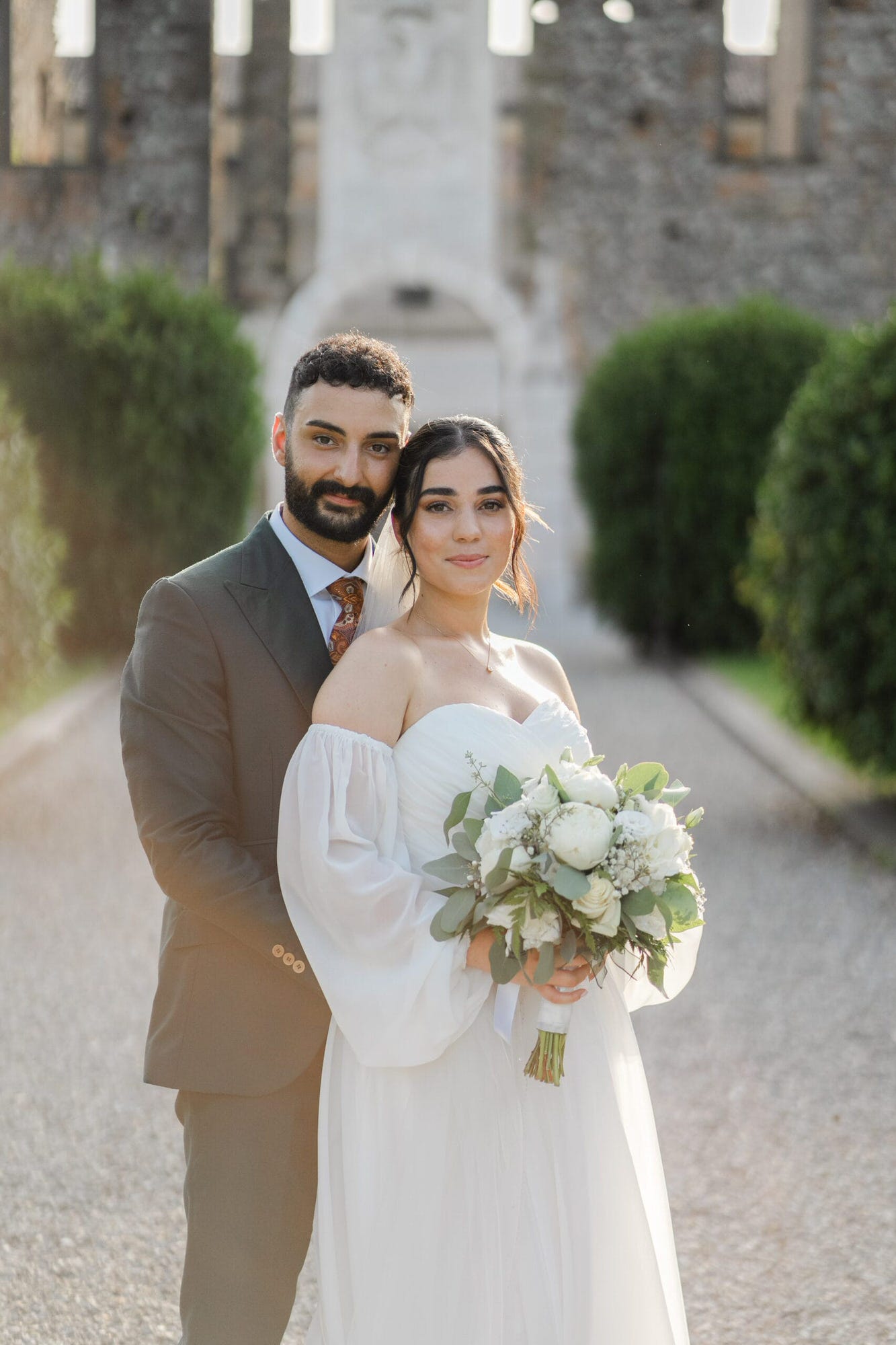 Un dolce abbraccio degli sposi in un angolo suggestivo del Castello di Cavernago, durante il loro matrimonio testimoni di Geova a Bergamo