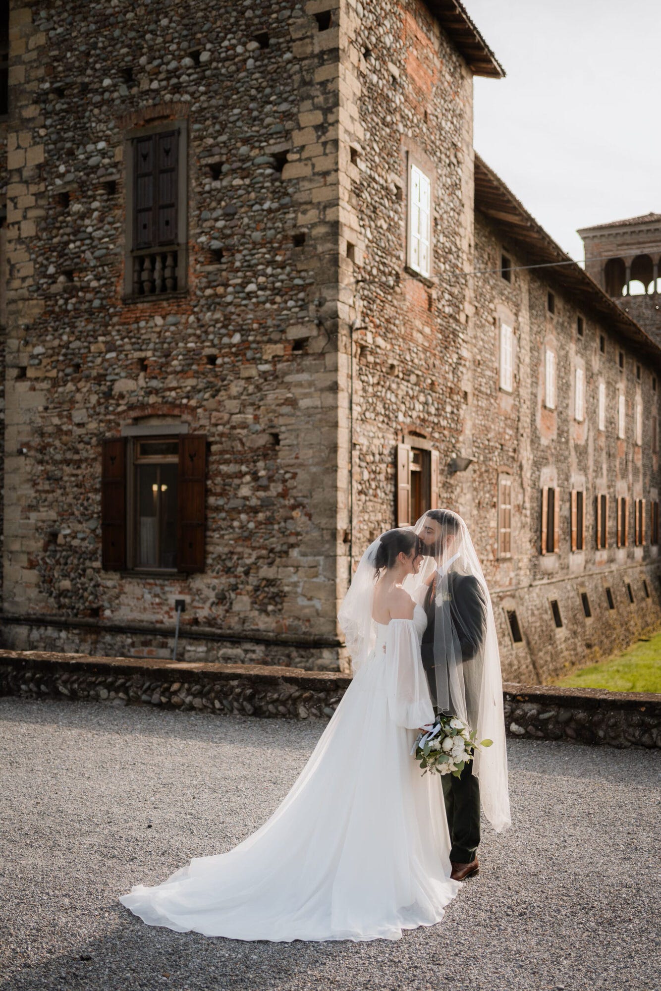 Un dolce abbraccio degli sposi in un angolo suggestivo del Castello di Cavernago, durante il loro matrimonio testimoni di Geova a Bergamo