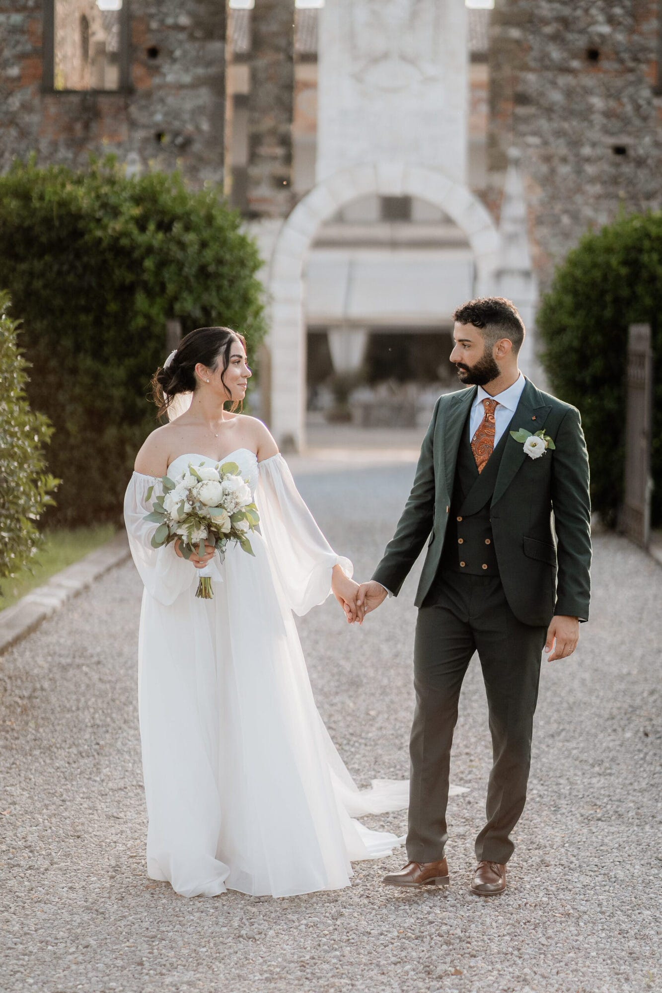 Un dolce abbraccio degli sposi in un angolo suggestivo del Castello di Cavernago, durante il loro matrimonio testimoni di Geova a Bergamo