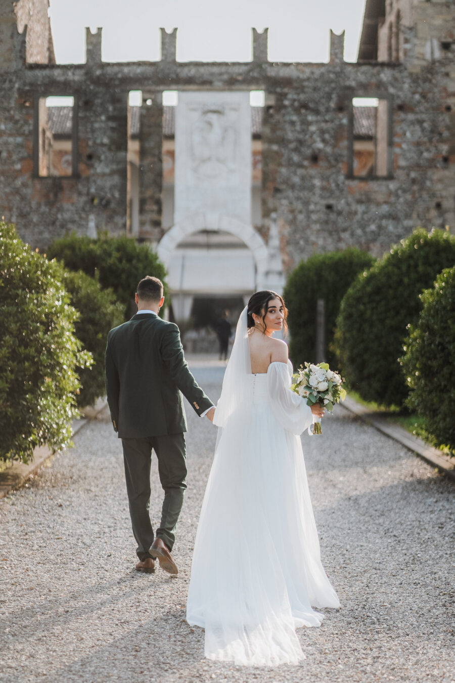 Un dolce abbraccio degli sposi in un angolo suggestivo del Castello di Cavernago, durante il loro matrimonio testimoni di Geova a Bergamo