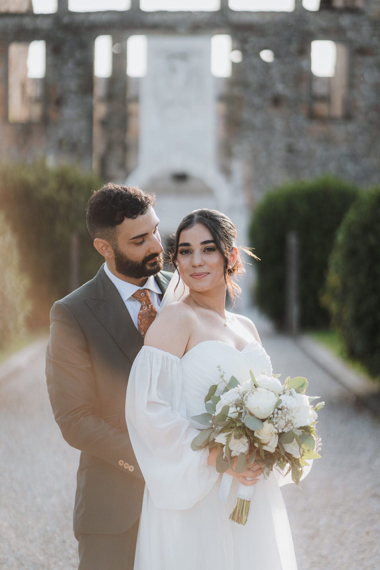 Un dolce abbraccio degli sposi in un angolo suggestivo del Castello di Cavernago, durante il loro matrimonio testimoni di Geova a Bergamo