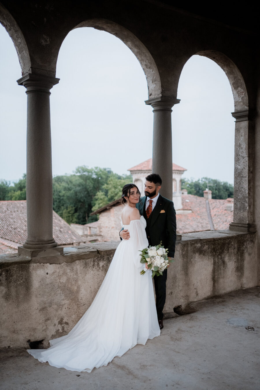 Un dolce abbraccio degli sposi in un angolo suggestivo del Castello di Cavernago, durante il loro matrimonio testimoni di Geova a Bergamo