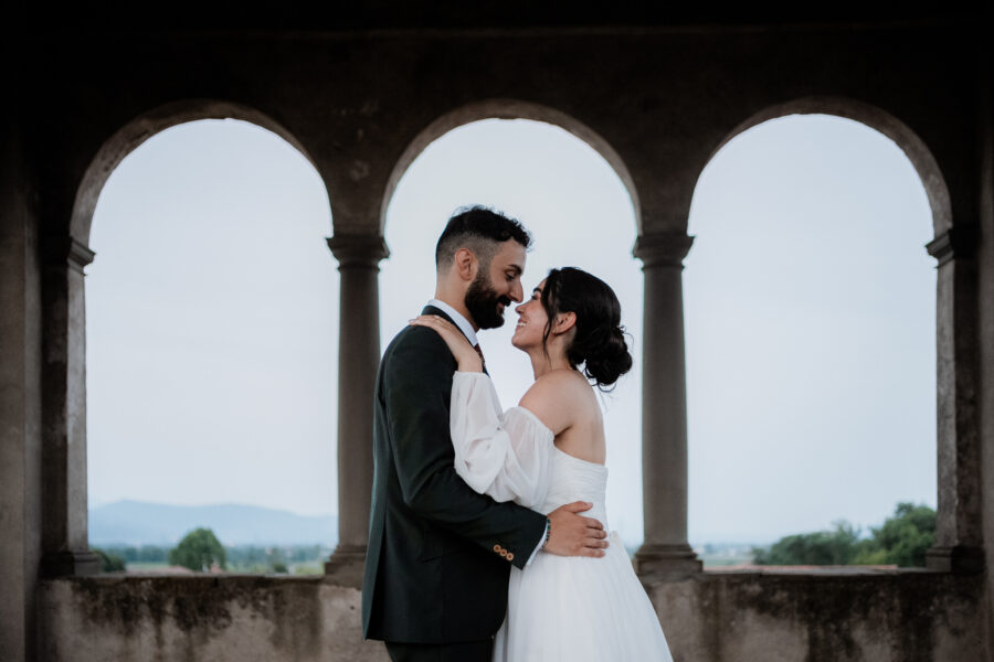Un dolce abbraccio degli sposi in un angolo suggestivo del Castello di Cavernago, durante il loro matrimonio testimoni di Geova a Bergamo